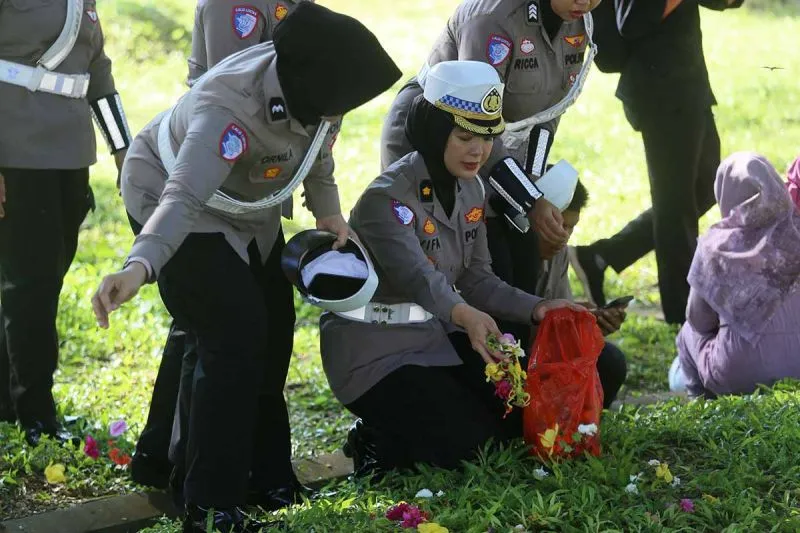 Polwan Ditlantas Polda Aceh menaburkan bunga di kuburan massal korban tsunami di Siron, Kabupaten Aceh Besar (ANTARA)