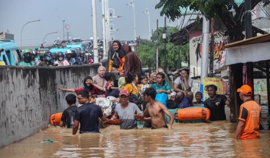 Petugas BPBD Jakarta bersama warga mengevakuasi warga saat banjir merendam kawasan Cililitan Kecil, Jakarta Timur (Dok. MI)