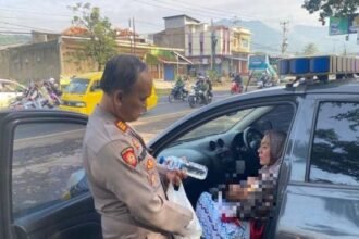 Polisi ketika mendampingi ibu dan bayi yang ditinggal suaminya di masjid saat perjalanan mudik (Dok. Humas Polres Tasikmalaya Kota)