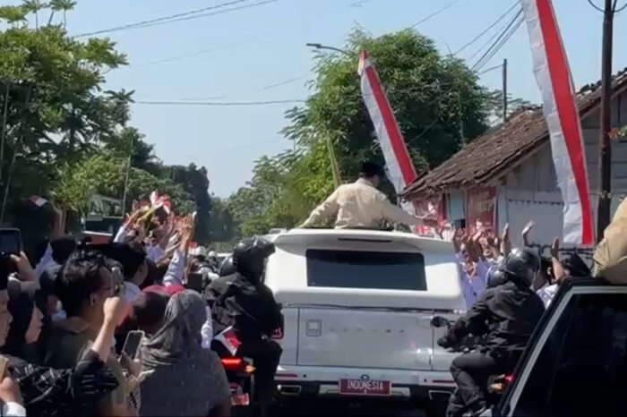 Presiden Prabowo Subianto menyapa warga Klaten dari sunroof mobil saat dalam perjalanan menuju peresmian Koperasi Desa Merah Putih, Senin (21/7).