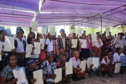 Menteri Transmigrasi M. Iftitah Sulaiman menyerahkan 400 sertifikat tanah di Desa Laimbaru, Sumba Timur, sebagai bentuk kepastian hukum bagi warga transmigran.