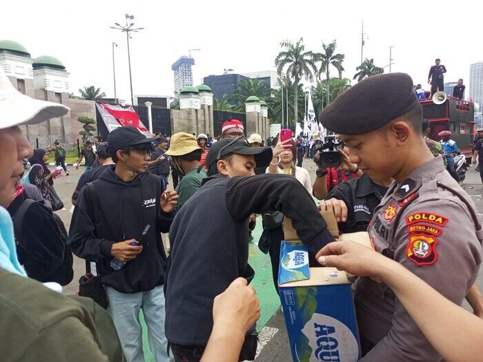 Polisi tunjukkan aksi simpatik dengan membagikan air mineral dan roti kepada buruh saat demo di DPR/MPR, wujudkan pengamanan humanis dan kondusif.