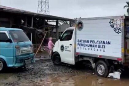 Mobil SPPG Padang menembus hujan deras untuk mengirim Makan Bergizi Gratis ke posko pengungsian.