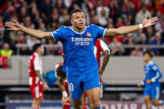 Kylian Mbappe memegang bola pertandingan usai memborong empat gol ke gawang Olympiakos.