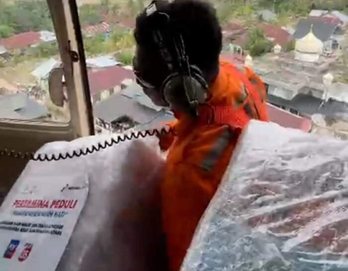 Helikopter Pertamina menebar bantuan dari udara untuk warga Aceh Tamiang yang terputus akses akibat bencana.