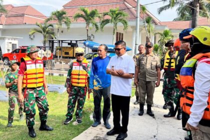 Relawan menyusuri Sungai Cibanten sambil membersihkan tumpukan sampah dalam rangka Hari Relawan Sedunia 2025.