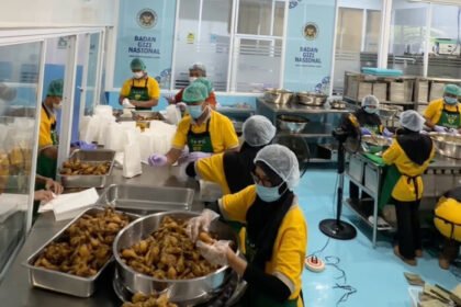 Petugas SPPG Bener Purworejo menyiapkan menu Jenang Pati Kirut dan Paha Ayam Goreng Kremes di dapur MBG untuk distribusi Ramadan 2026.
