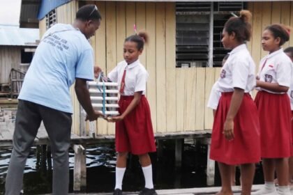 Speed boat pengantar Program Makan Bergizi Gratis tiba di dermaga sekolah di pesisir Danau Sentani dan langsung disambut antusias oleh anak-anak Papua.