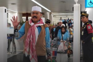 Petugas Imigrasi memandu jemaah haji menggunakan fasilitas corridor gate saat tiba di Bandara Soekarno-Hatta untuk mempercepat proses pemeriksaan keimigrasian.