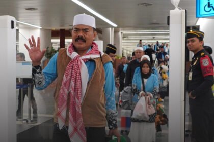 Petugas Imigrasi memandu jemaah haji menggunakan fasilitas corridor gate saat tiba di Bandara Soekarno-Hatta untuk mempercepat proses pemeriksaan keimigrasian.