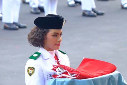 Paskibraka asal Papua Neeltje Deliana Insjowi Werimon menjalankan tugas membawa baki pada Upacara Penurunan Bendera HUT ke-81 RI di Istana Merdeka.