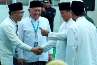 Presiden Prabowo Subianto menerima kartu anggota NU saat penutupan Muktamar Ke-35 NU di Pondok Pesantren Bahrul Ulum Tambakberas, Jombang.