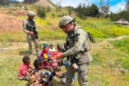 Personel Satgas Damai Cartenz berinteraksi dengan anak-anak saat patroli humanis di Ilaga, Kabupaten Puncak, Papua Tengah.