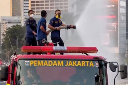 Petugas menyemprotkan air menggunakan armada water mist di Jalan Jenderal Sudirman, Jakarta, sebagai langkah antisipasi paparan abu vulkanik Gunung Anak Krakatau.