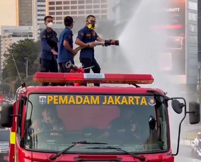 Petugas menyemprotkan air menggunakan armada water mist di Jalan Jenderal Sudirman, Jakarta, sebagai langkah antisipasi paparan abu vulkanik Gunung Anak Krakatau.